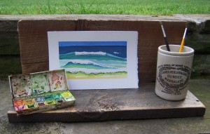 an assemblage using a barn board shelf, an old jr, brushes, a paint box and an original watercolor