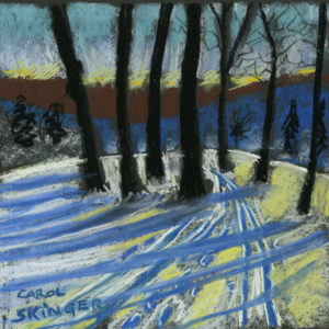 Trees cast long shadows on snow, ski tracks and footprints in snow, deep blue hill and russet foliage beyond, Winter sky has yellow glow and viridian green. 12” x 12” Soft pastel on paper by Carol Skinger